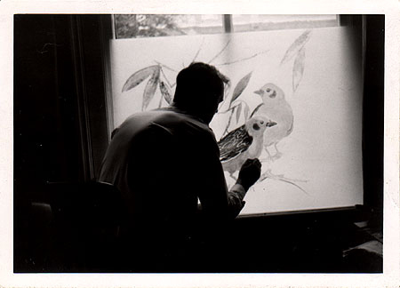 Abraham Krijger, oprichter van Krijger Zeefdruk, beschildert een glazen wanddecoratie voor een restaurant